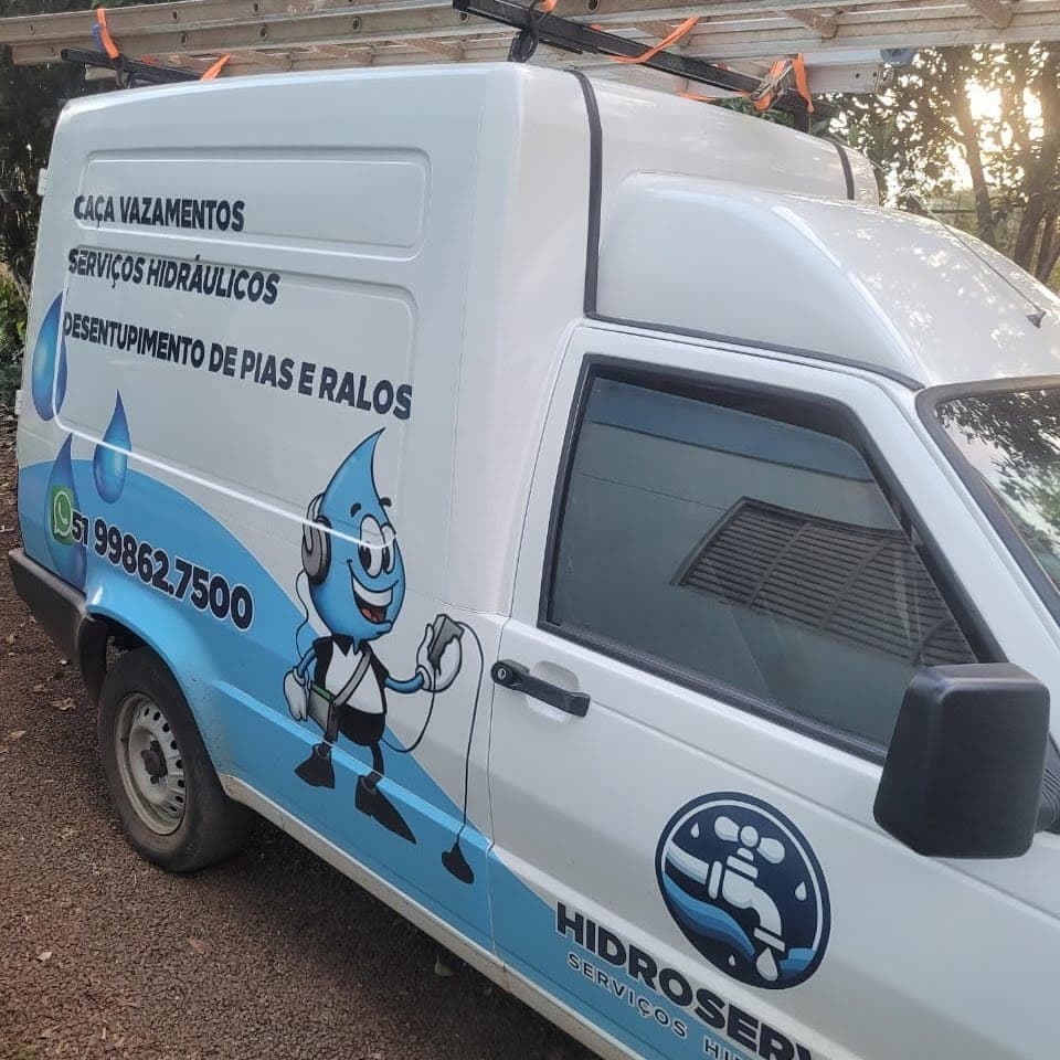 Unidade móvel da Hidroservice adesivada com os serviços e o telefone na lateral, equipada para atendimento em domicílio